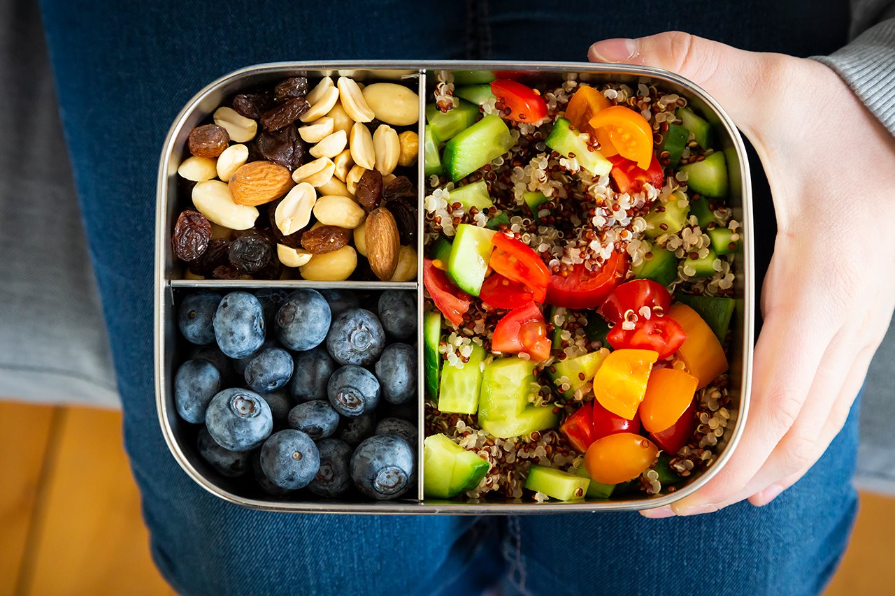 lunch box with nuts, blueberries, quinoe, cucumbers, tomatoes