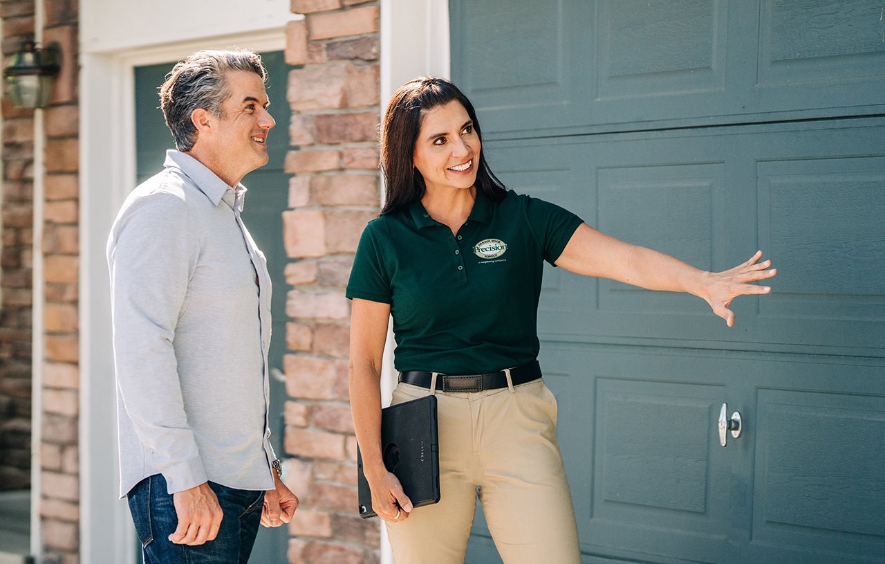 Representative from Precision garage door outside with homeowner talking about garage door.