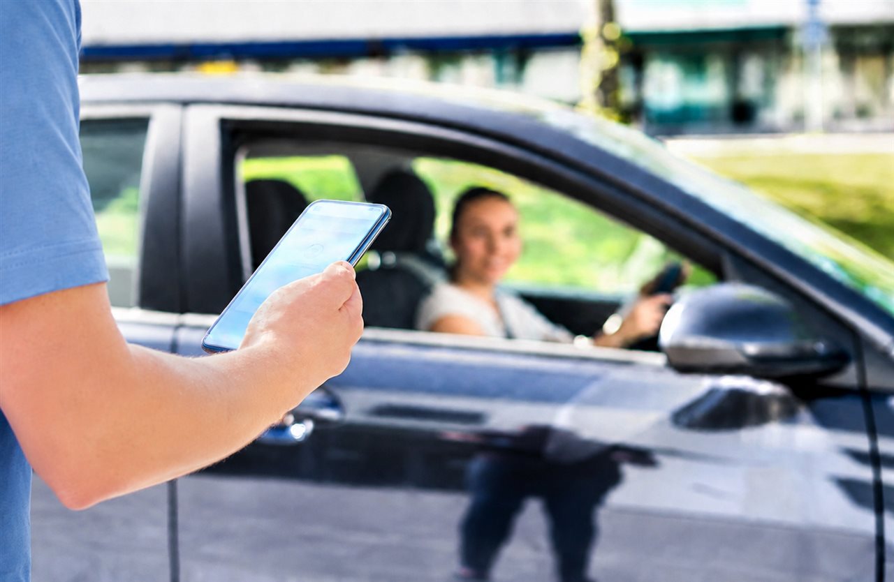 Man using a phone app to get a ride share.