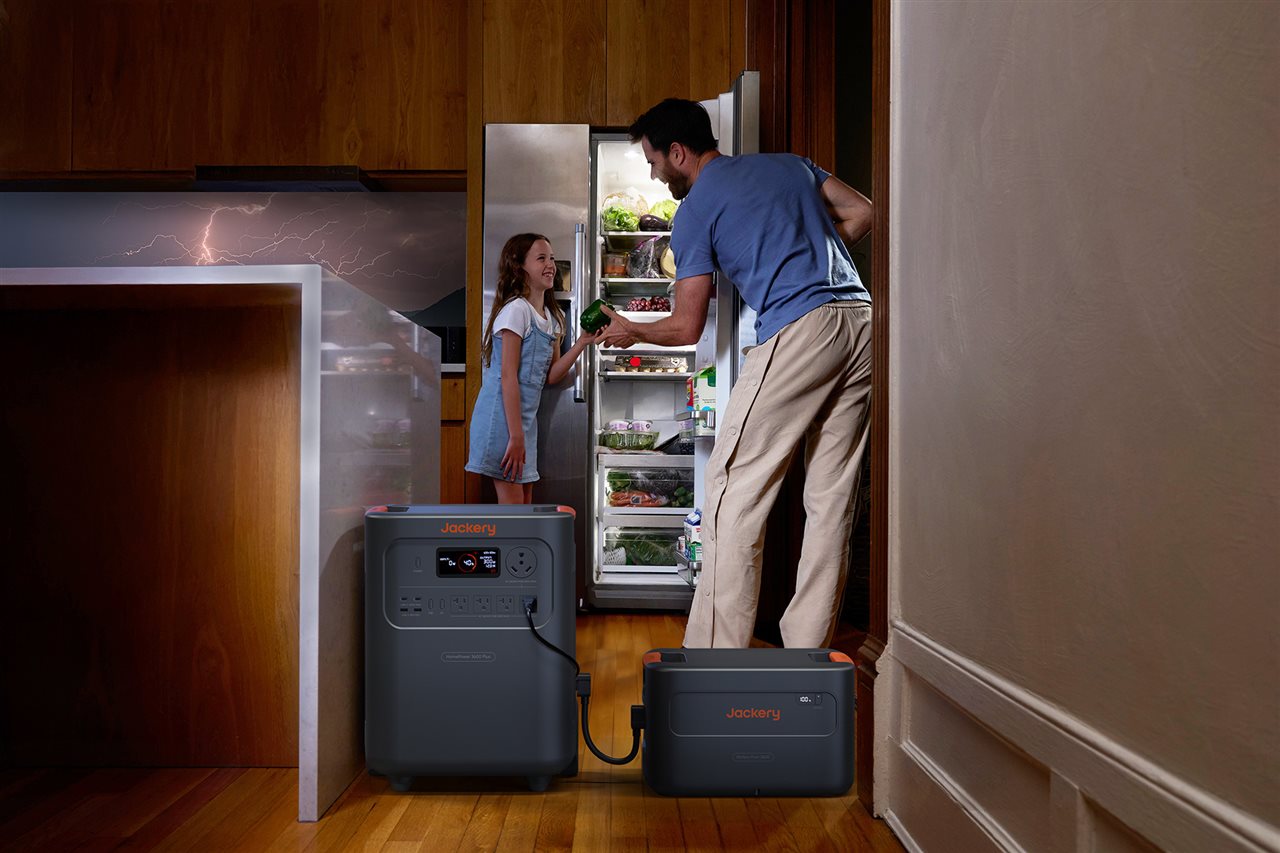 Dad and daughter in kitchen using a a Jackery 3600 plus for power during a storm.