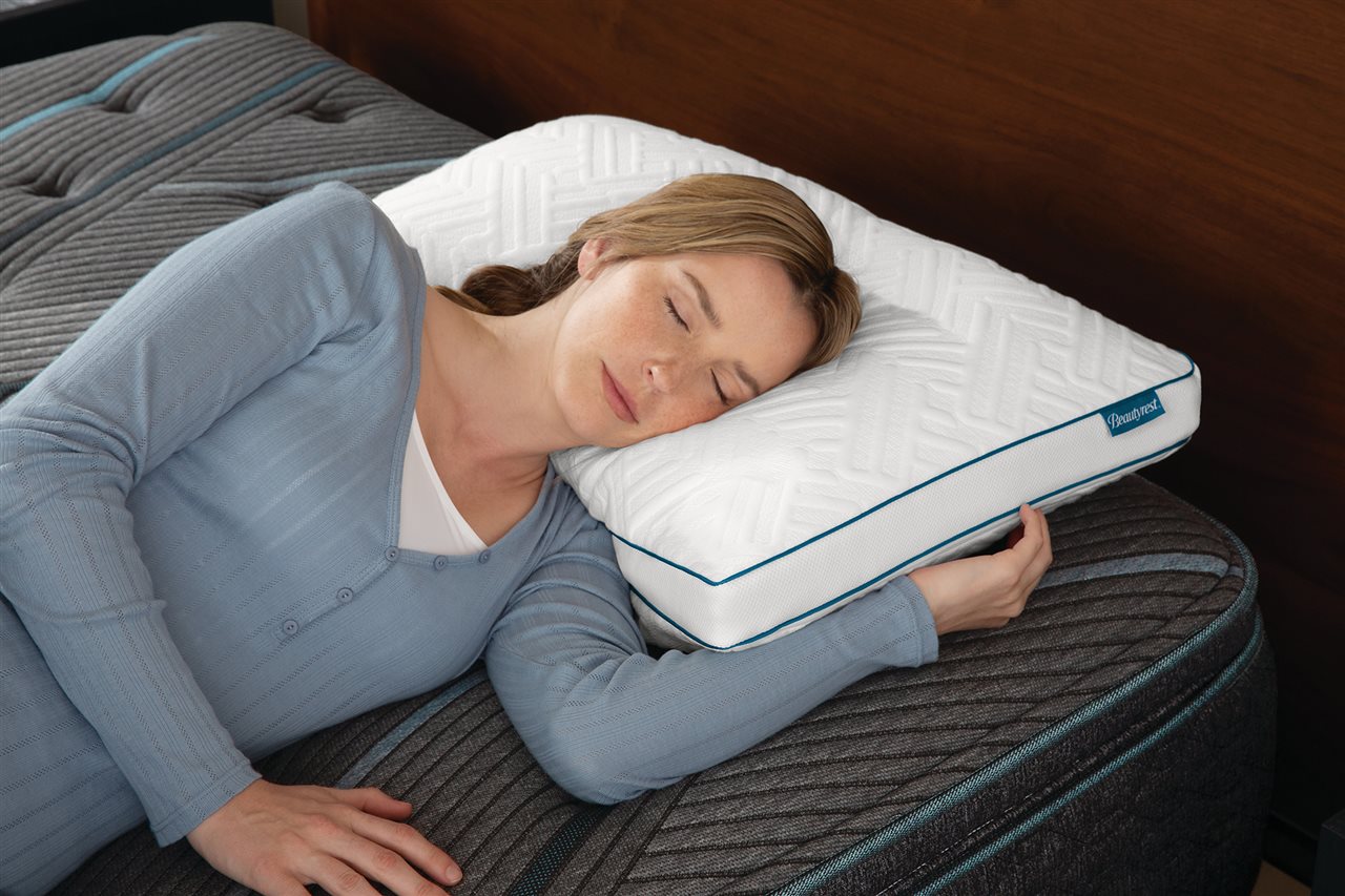 A woman sleeping on a Beautyrest<sup><sup><sup><sup><sup>&reg;</sup></sup></sup></sup></sup> Deluxe Down Alternative Pillow.