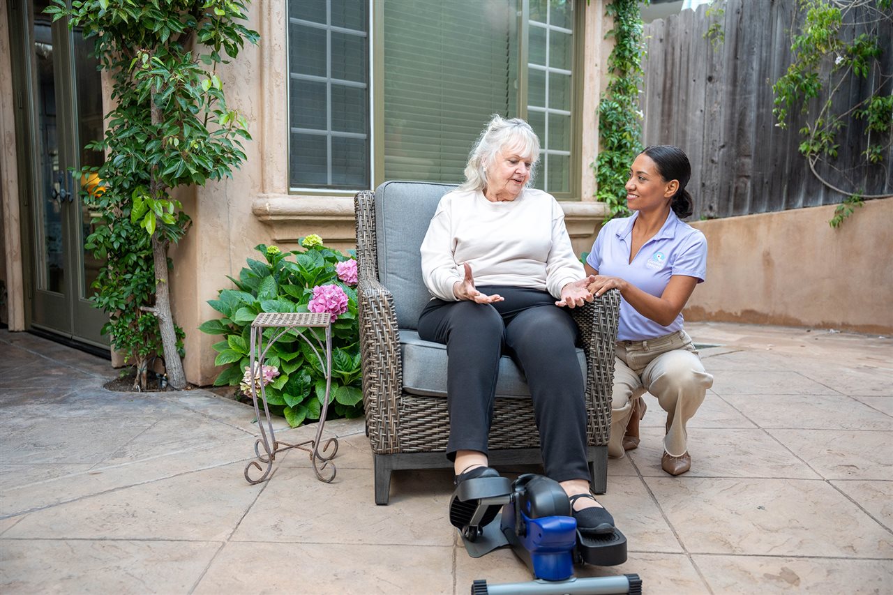 Member of the Comfort Keepers team assisting an aging senior with exercise.