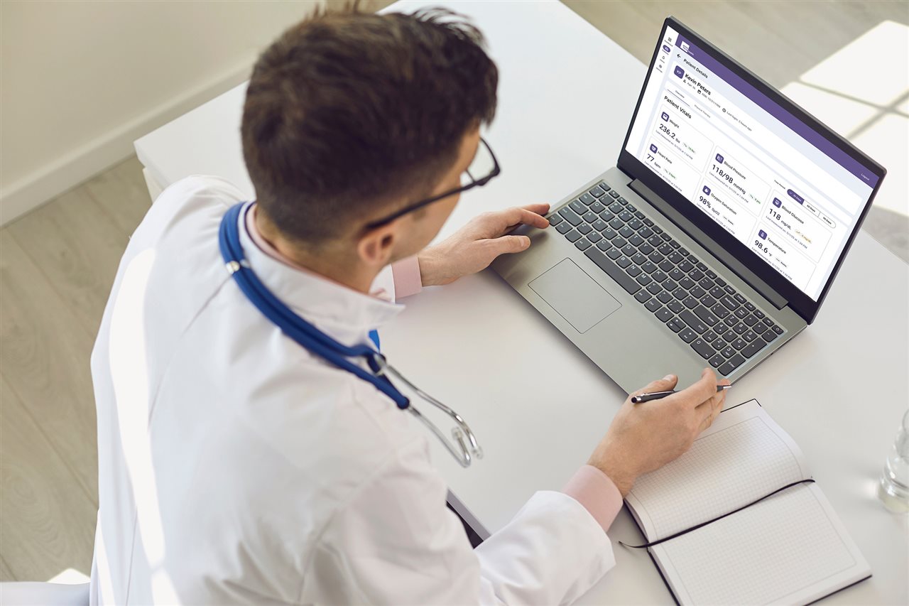 Doctor looking at patient record on laptop. Primefocus Health reimagines how healthcare happens beyond the clinic.