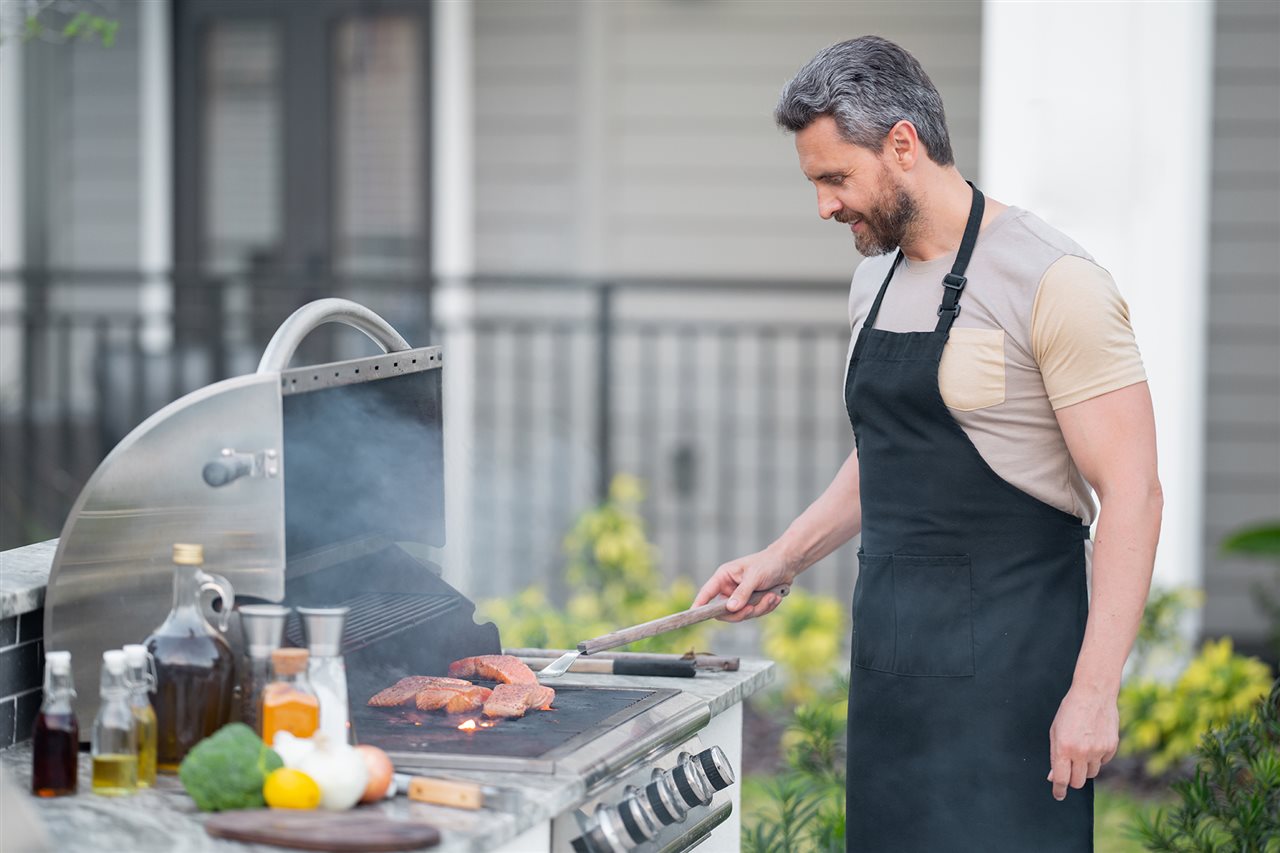 Man grilling Chilean salmon in the backyard.