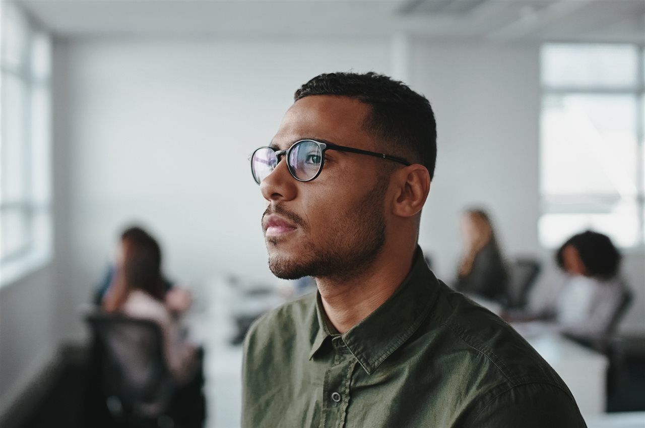 Man wearing glasses looking out the window.