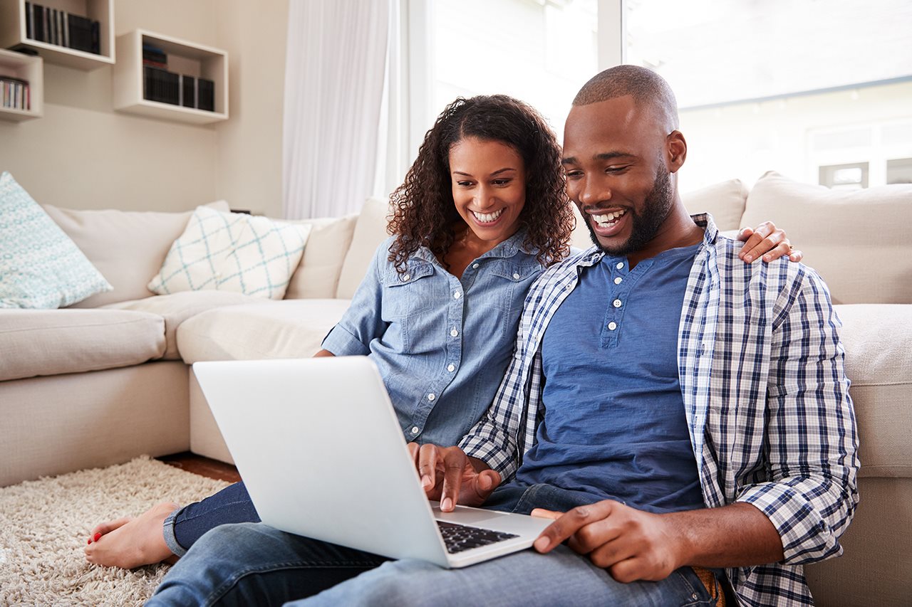 Couple looking for houses online while in their livingroom