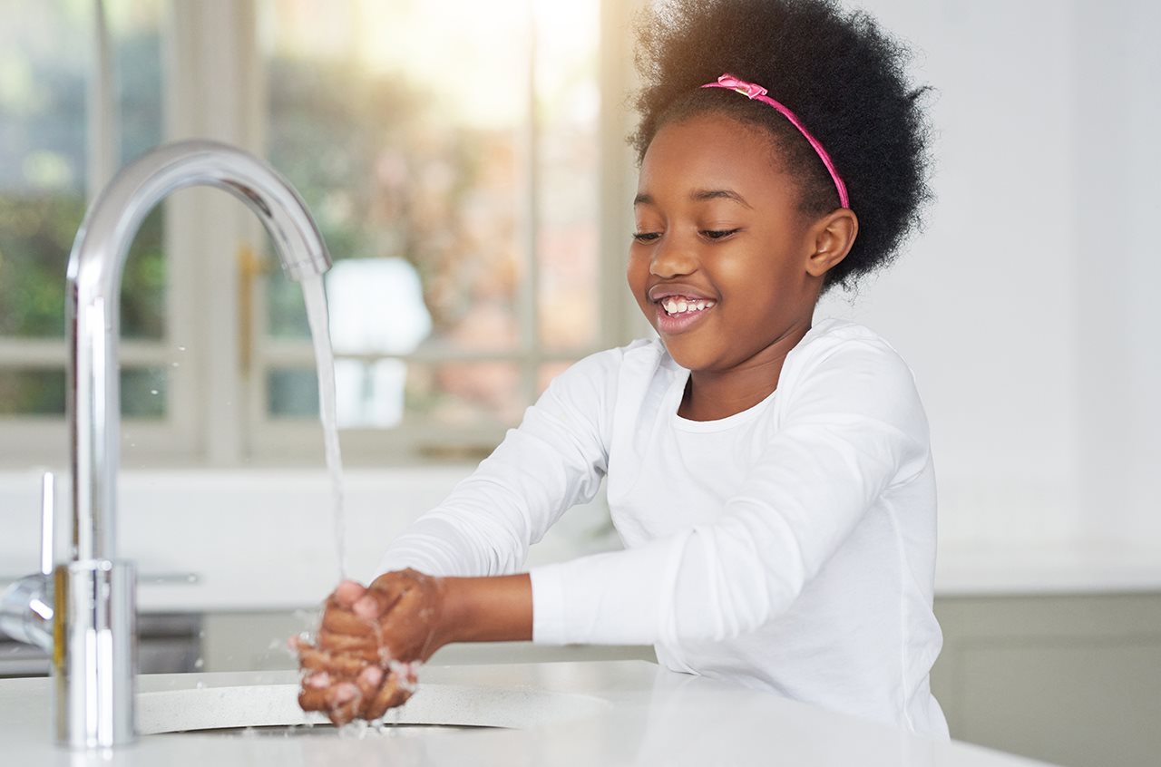 Girl washing hands in a sink