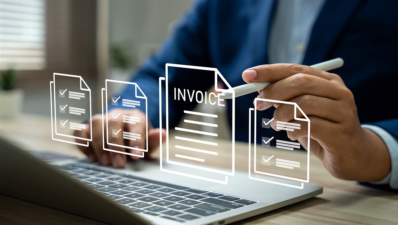 Business owner at laptop using AI agents to accelerate and automated bill payments.