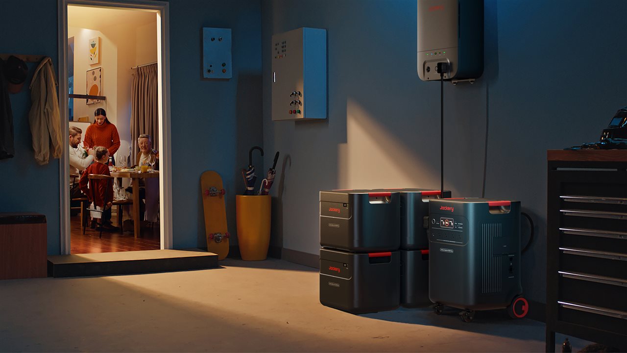Family having dinner in the kichen while the Jackery Solar Generator 5000 Plus powers their home from the garage.