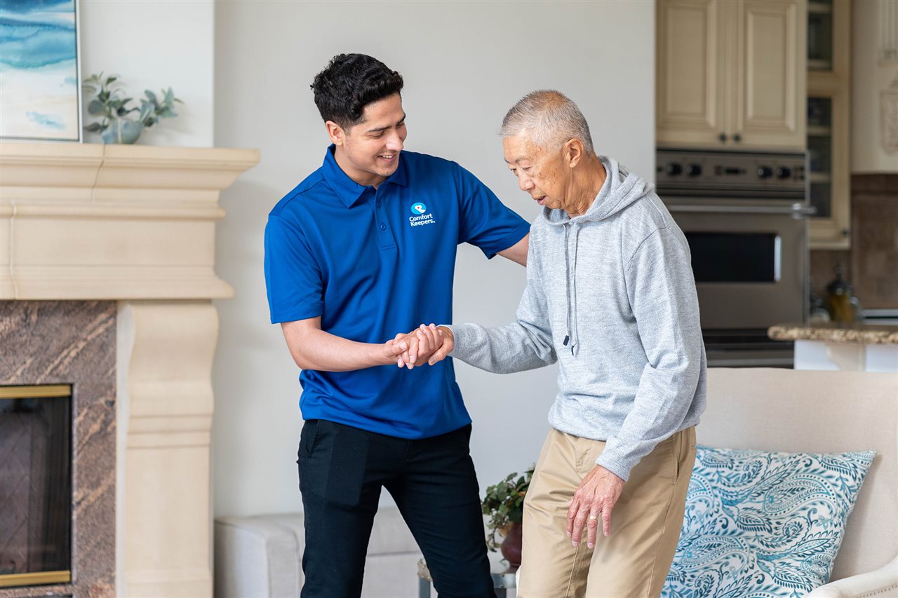 Member of Comfort Keepers team helps an aging senior with mobility.
