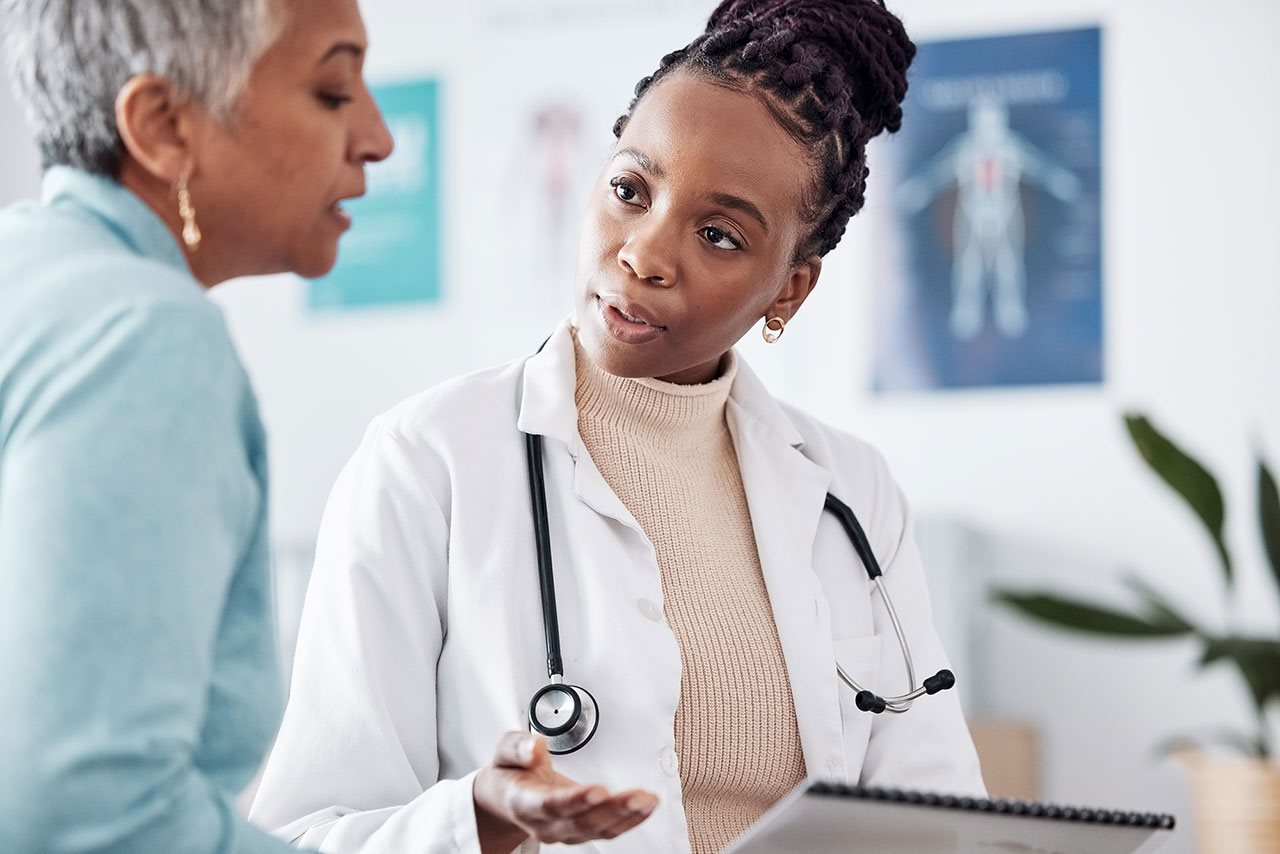 Older woman talking with doctor in an exam room